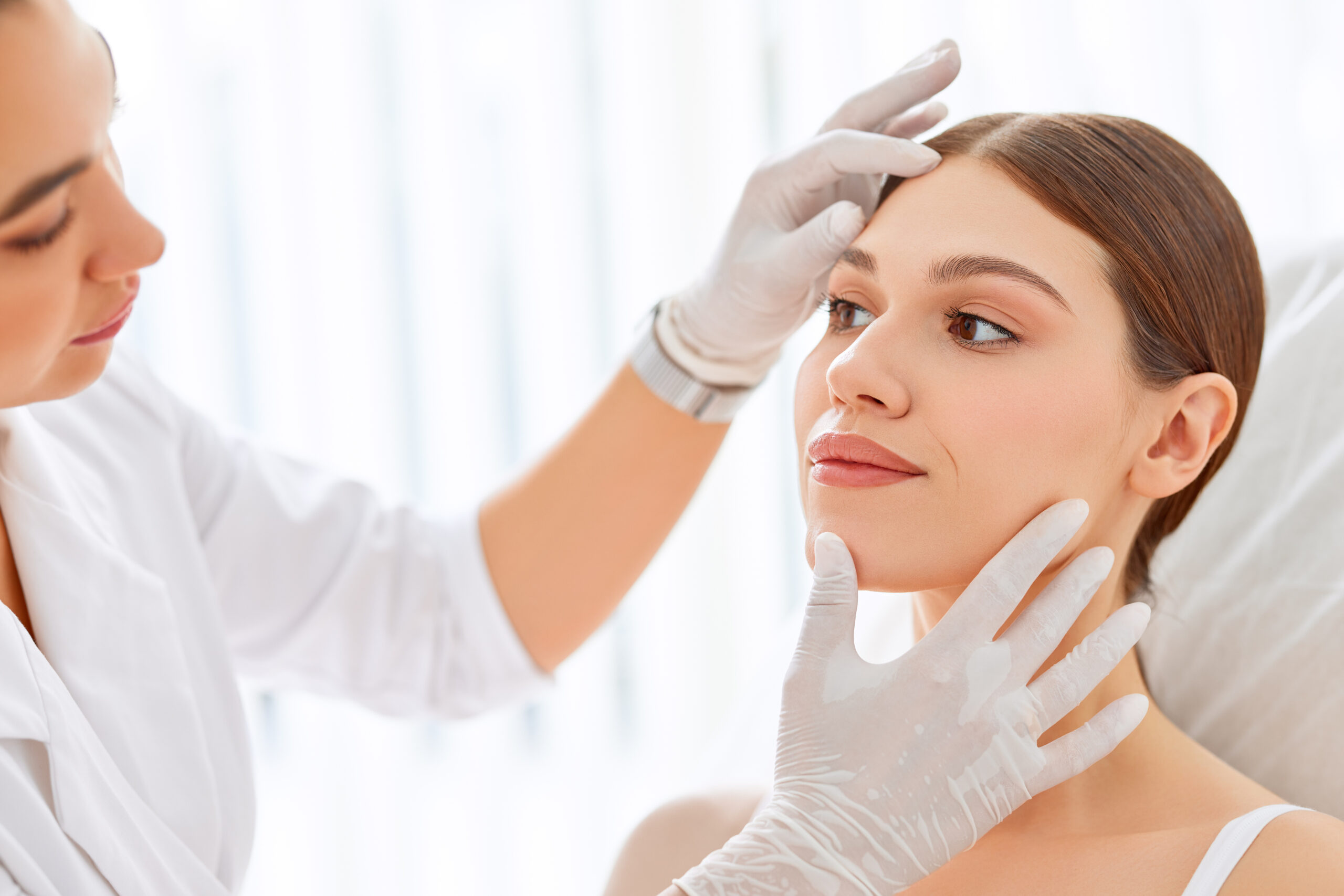 a woman getting her face looked at by an aesthetician after getting a laser treatment in San Antonio.